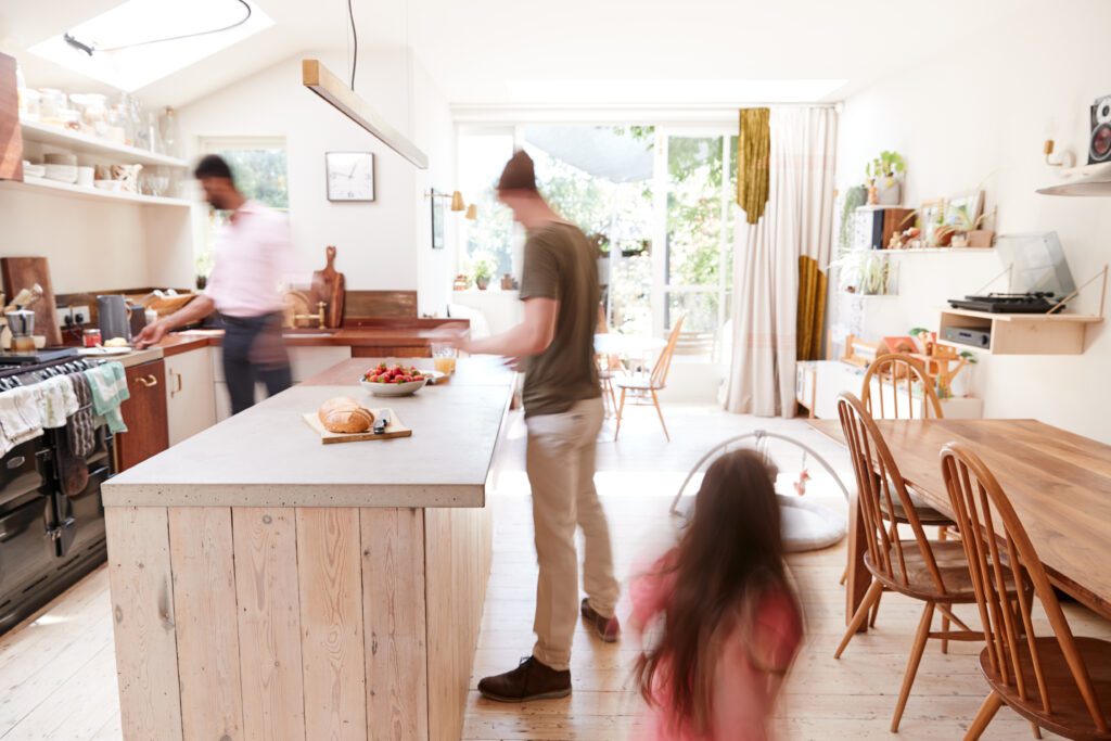 Couple With Daughter Making Breakfast At Home Together