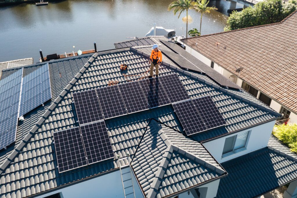 Man installing solar panels on the roof of a house